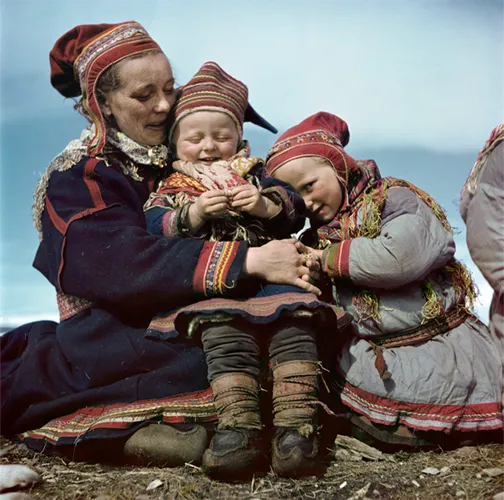A woman holding two children.