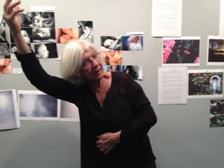 A woman standing behind photos.