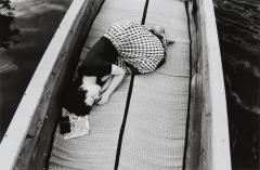 A woman sleeping in a boat. 