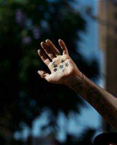 A hand with star tattoos. 