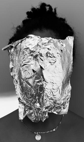 A profile of someone with textured hair, their face covered with tinfoil. 