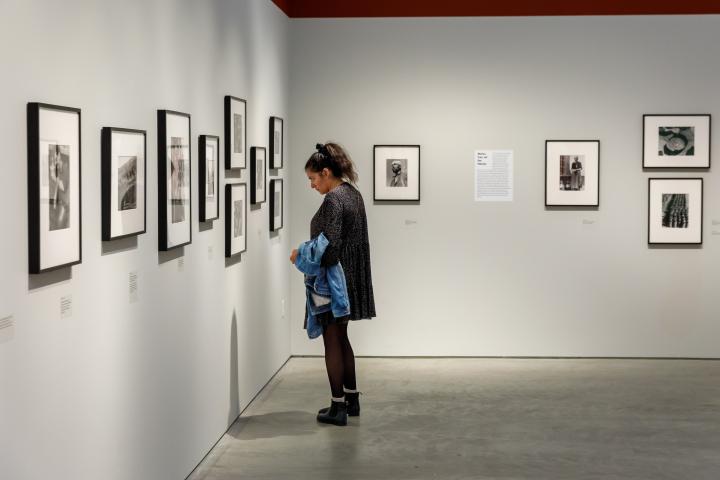 A woman looking at a photograph at an ICP exhibit. 