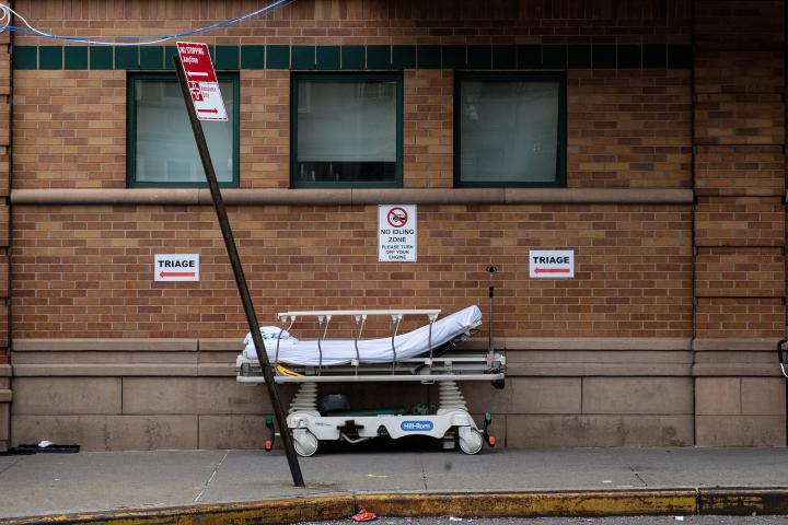 An abandoned hospital bed on a city street.  
