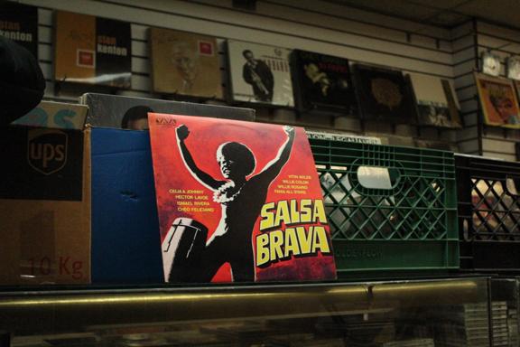 Crates of records inside a record store and one record, "Salsa Brava" leaning against a milk crate. 