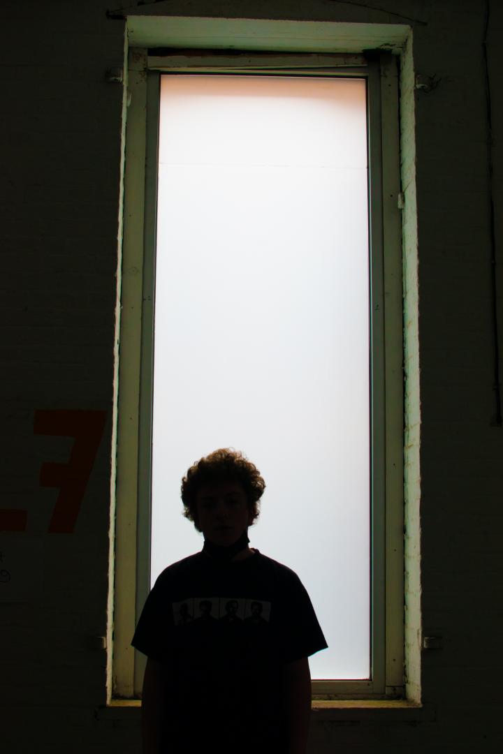 Kid looking out a tall window