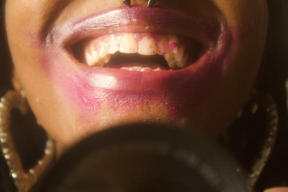A photo of a woman's lips with lipstick all over her lips and teeth