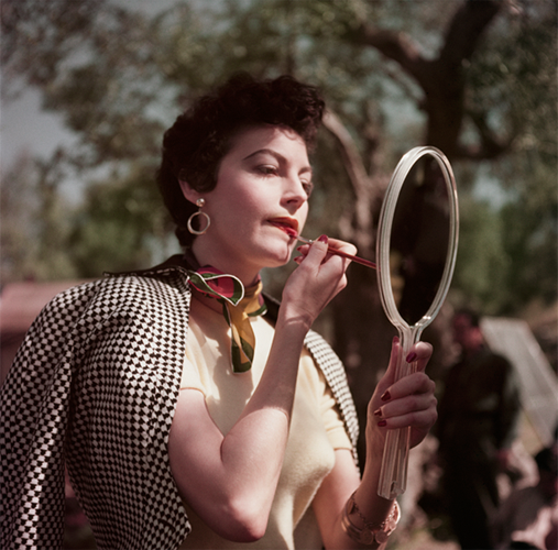 A woman retouching her lipstick.